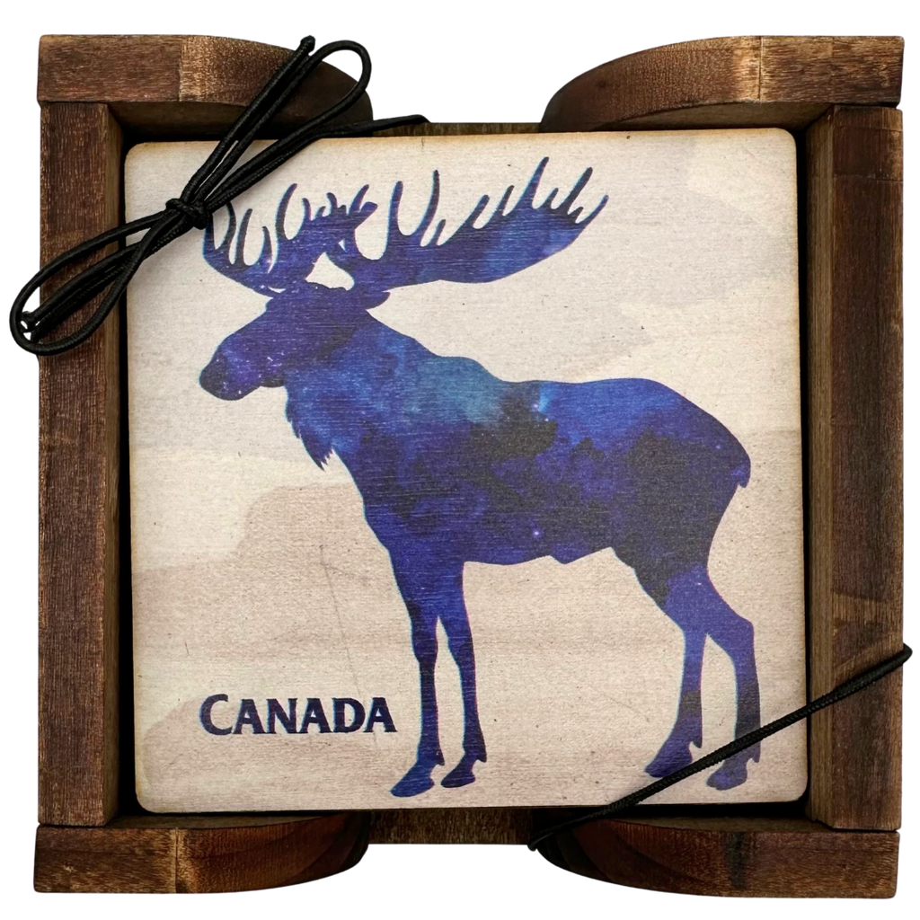 A square wooden coaster displayed in an attractive wooden holder. The coaster shows a moose in silhouette facing to the left. Inside the moose is a scene of a starry night sky. The coaster says "Canada" in the bottom left.