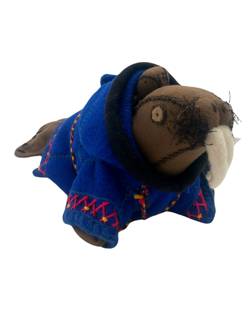 A hand-stitched felt doll of a brown walrus wearing a blue parka with embroidered red and yellow trim. The walrus carries a baby walrus on its back.