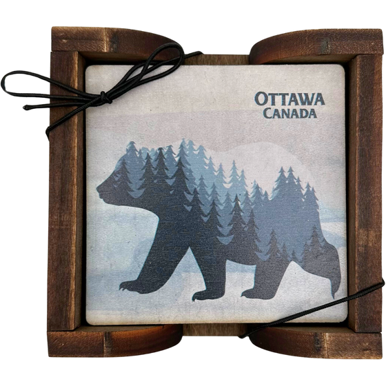 A square wooden coaster displayed in an attractive wooden holder. The coaster shows a bear in silhouette walking against a distressed wood background. Inside the bear is a graphic of a forested mountainscape. In the top left, the coaster says "Ottawa Canada"