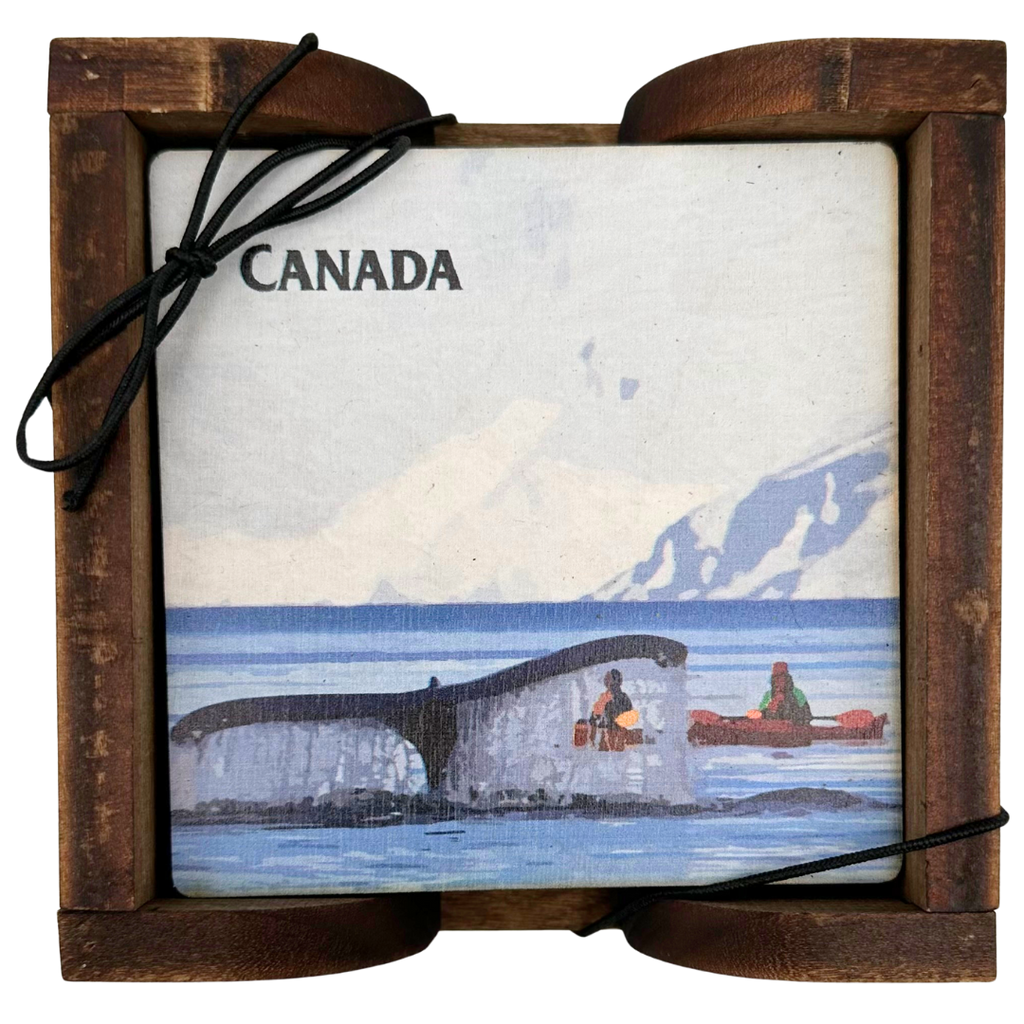 A square wooden coaster displayed in an attractive wooden holder. The coaster shows a whale fluke about to slap the water. Two people in kayaks observe in the midground, with a mountain in the background. The coaster says "Canada" in the top left corner.