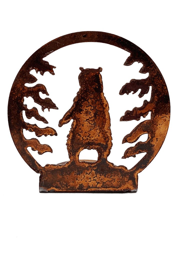 A bear stands on hind legs, flanked by pine trees. The scene is cut from sheet steel and then oxidised to a tasteful red patina.