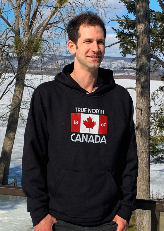 Black pullover hoodie with Canadian flag in center with 1867 flanking maple leaf and the words TRUE NORTH above and CANADA below the flag.