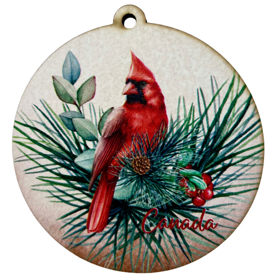 A brilliant red cardinal sits in a holly bough. In the bottom right reads "Canada" in red script.