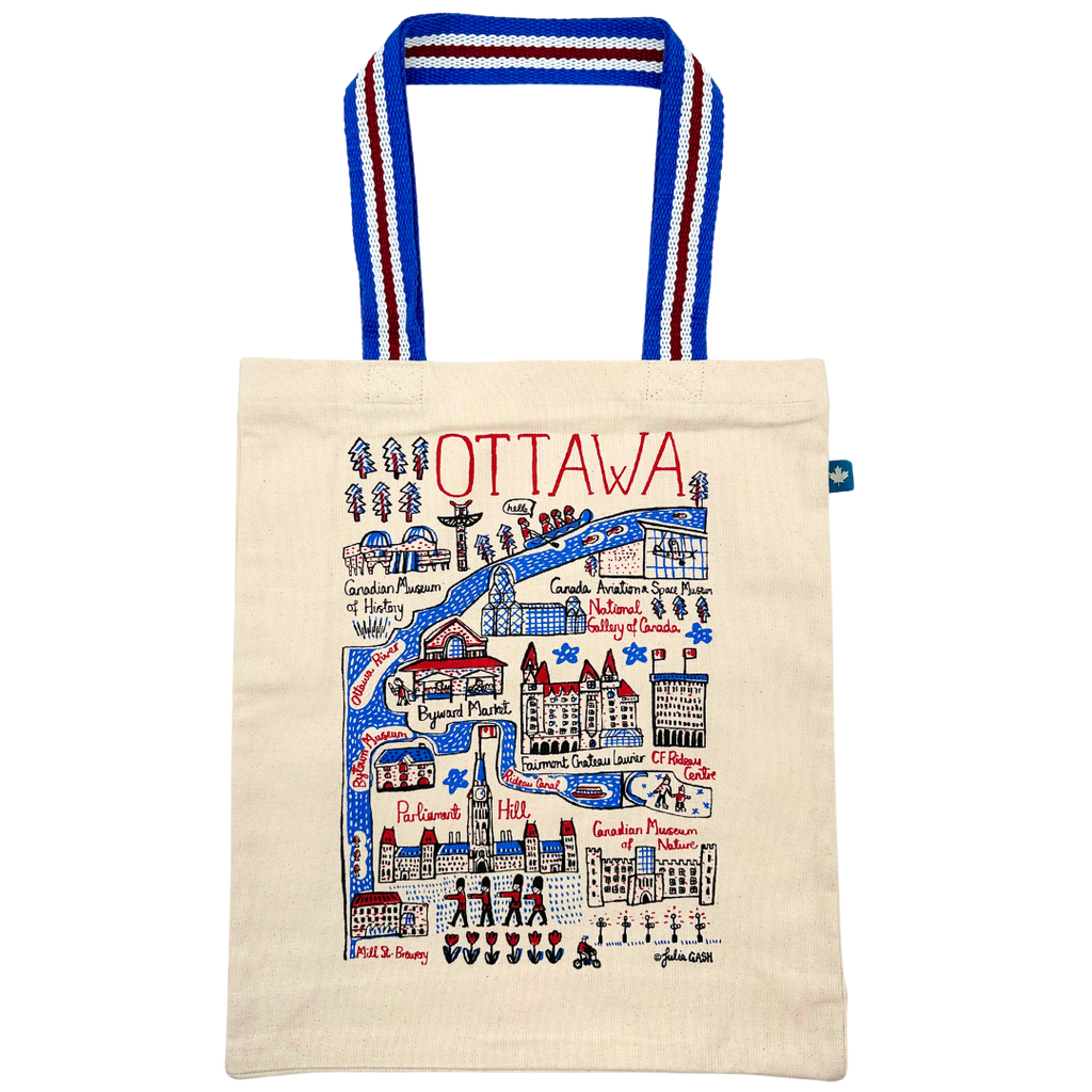 Light Beige tote bag with doodles of popular spots in Ottawa on it in  red, blue, and black. The straps of the tote bag are  blue with 1 red and 2 white stripes.