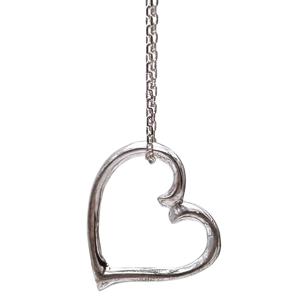 A sterling silver heart charm hangs from a silver chain on a black background. The chain attaches to the top left of the heart. The heart is asymmetrical and appears to curl towards the right.