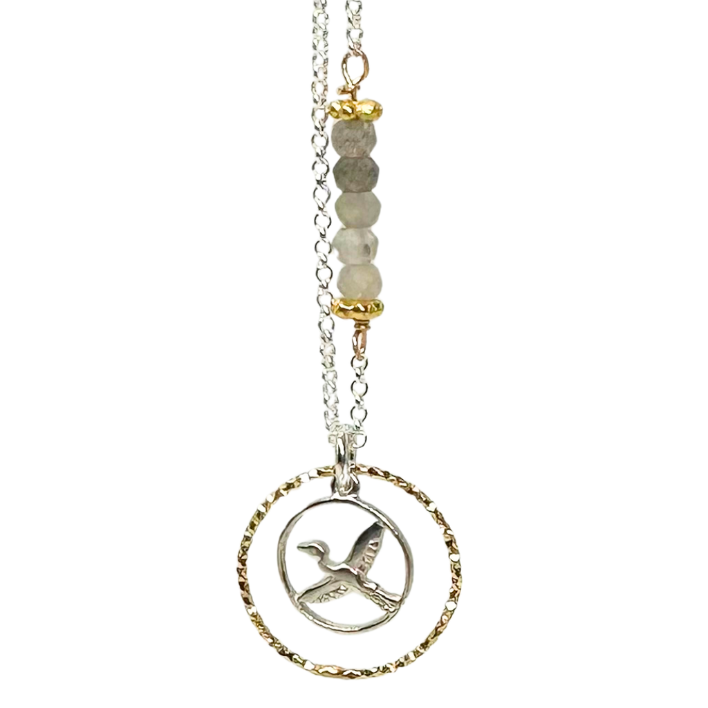 Silver chain with 5 coloured beads in middle of chain attached with gold chain links that look like flowers. Pendent is a gold ring that has triangle ridges. Small silver ring inside the gold one with a heron in the center.