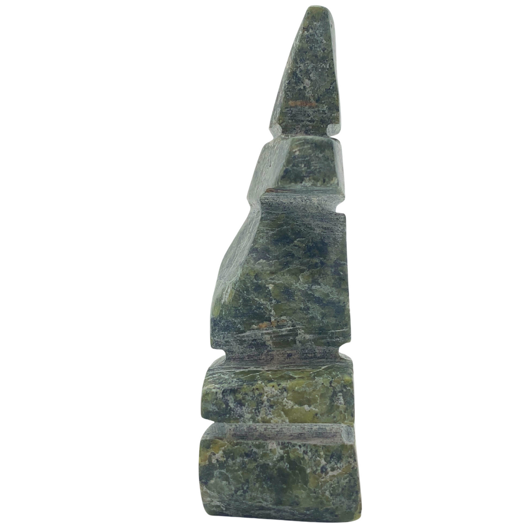 A human-shaped inukshuk sculpture, approximately 3 inches high. The stone is mottled black and green soapstone.