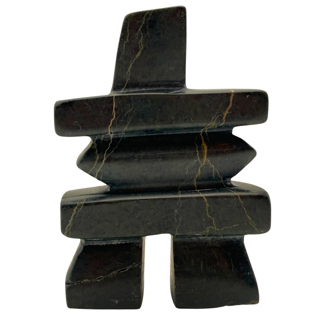 A human-shaped inukshuk sculpture, approximately 4 inches high. The stone is mottled black and green soapstone.