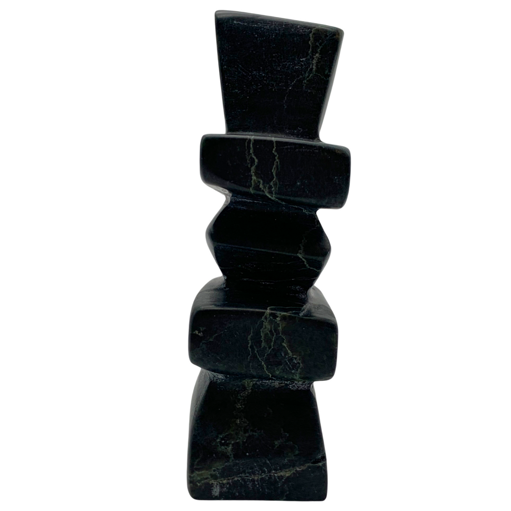 A human-shaped inukshuk sculpture, approximately 4 inches high. The stone is mottled black and green soapstone.