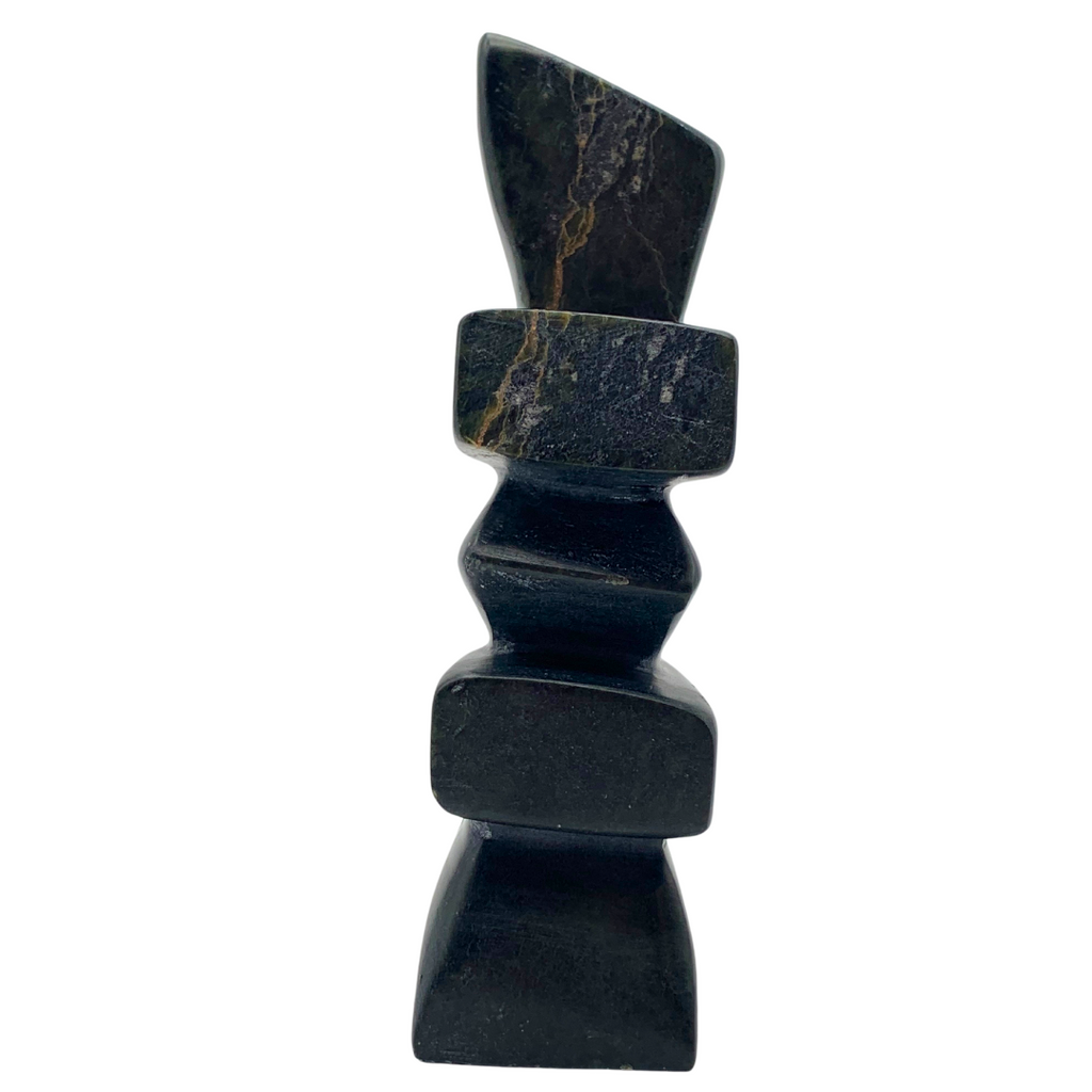 A human-shaped inukshuk sculpture, approximately 5 inches high. The stone is mottled black and green soapstone.