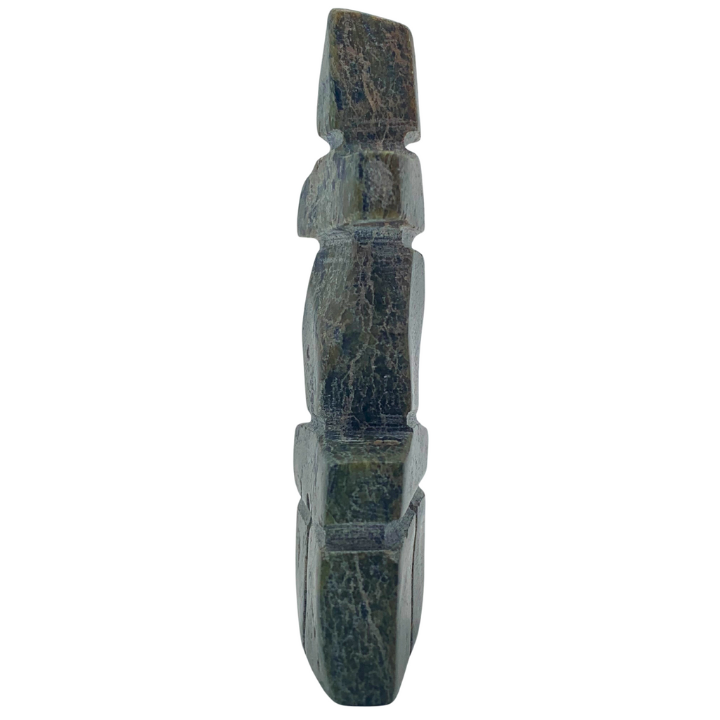 A human-shaped stone sculpture. The stone is mottled green and black serpentine.