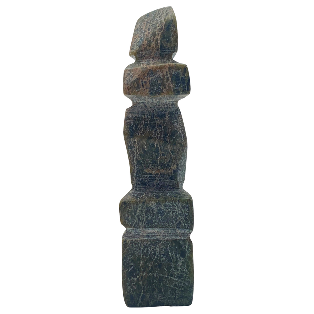 A human-shaped stone sculpture. The stone is mottled green and black serpentine.