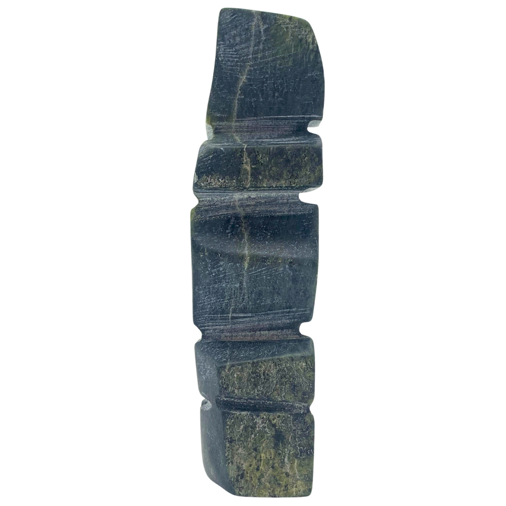 A human-shaped inukshuk sculpture, approximately 4 inches high. The stone is mottled black and green soapstone.