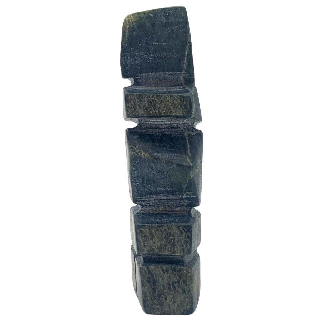 A human-shaped inukshuk sculpture, approximately 4 inches high. The stone is mottled black and green soapstone.