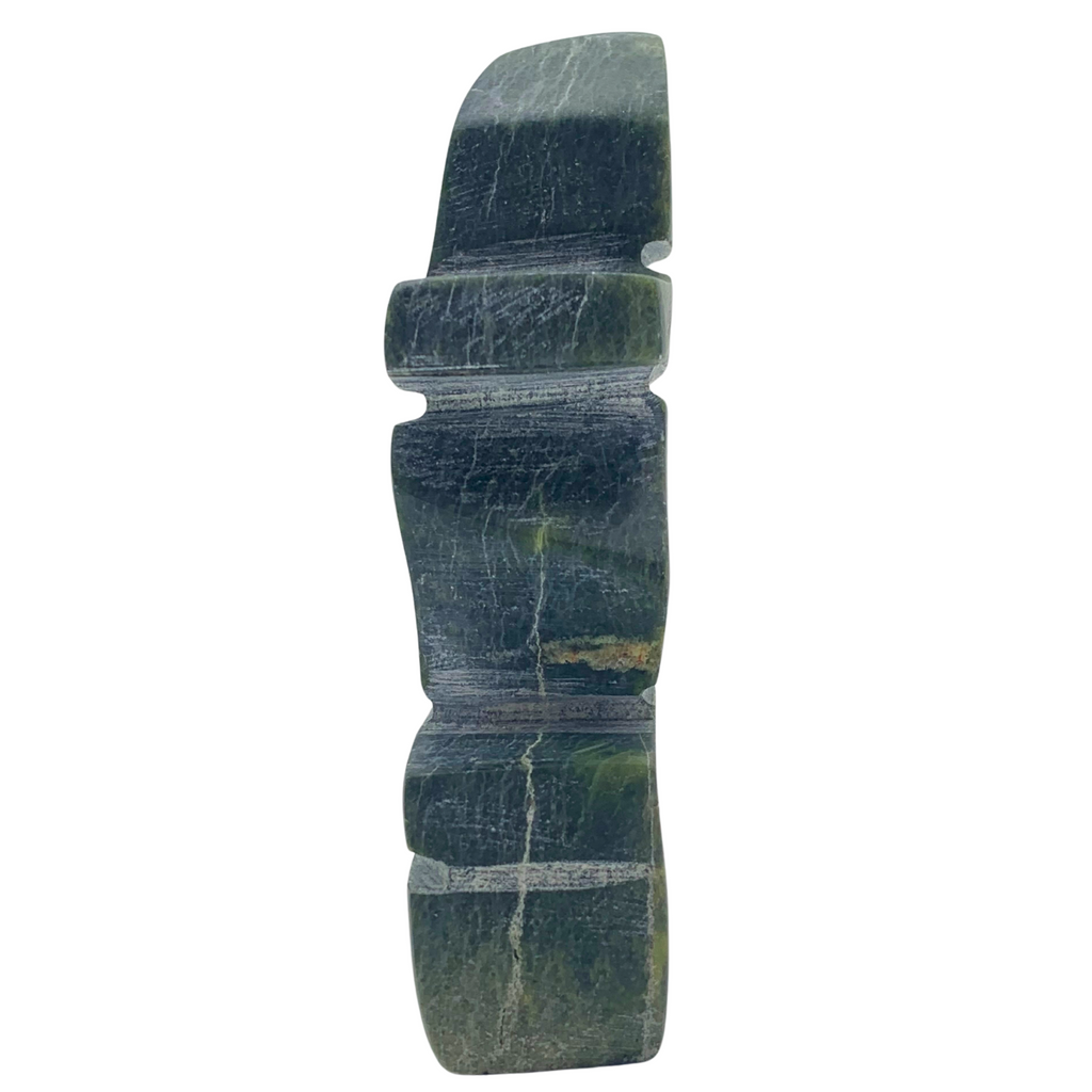 A human-shaped inukshuk sculpture, approximately 4 inches high. The stone is mottled black and green soapstone.