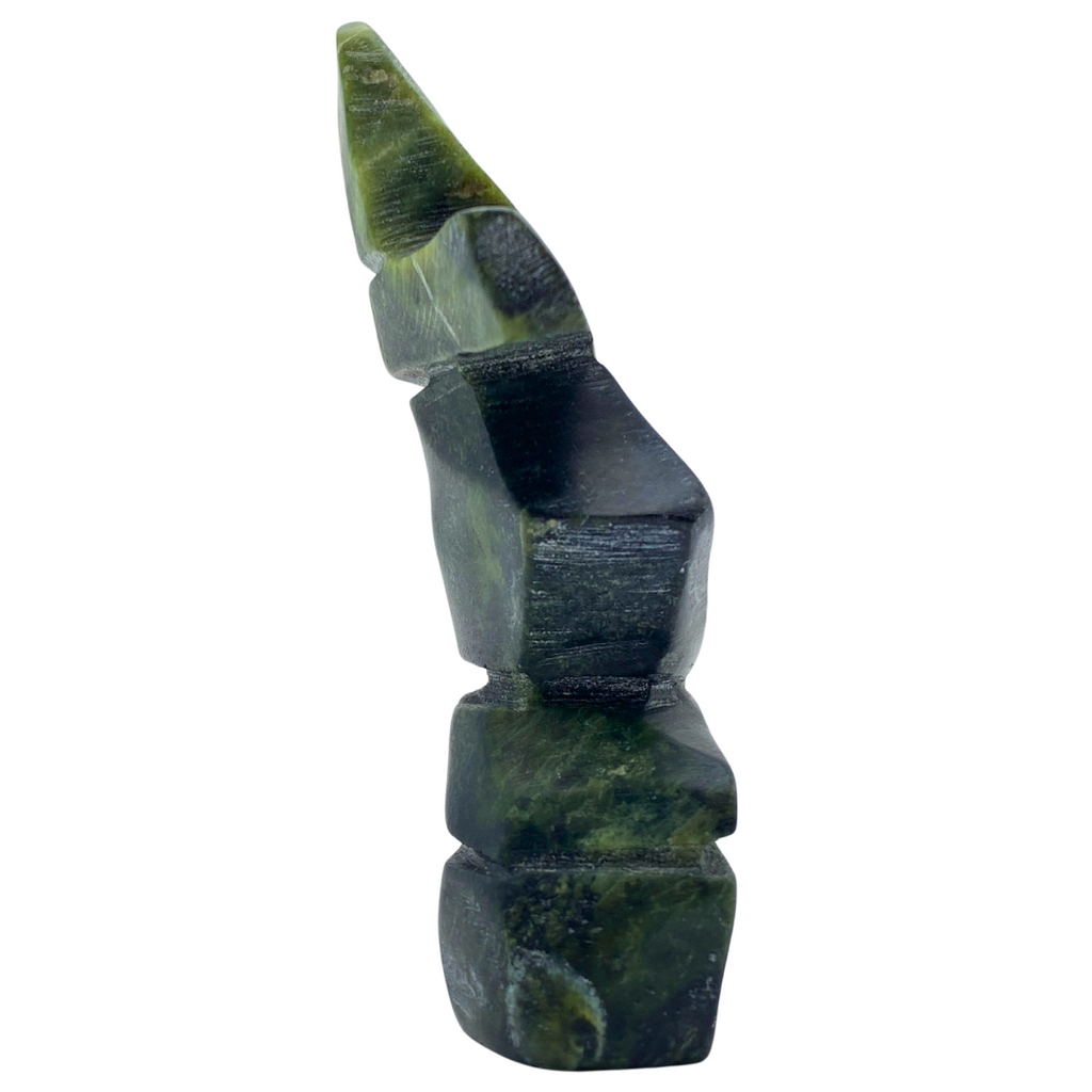 A human-shaped inukshuk sculpture, approximately 4 inches high. The stone is mottled black and green soapstone.