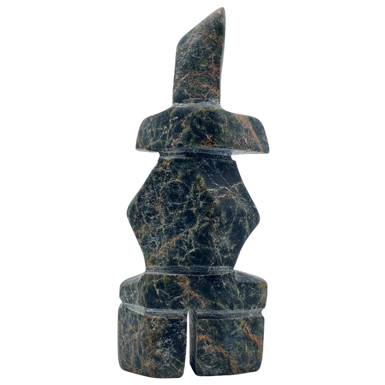 A human-shaped inukshuk sculpture, approximately 4 inches high. The stone is mottled black, brown and green soapstone.