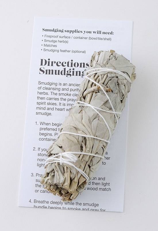 A traditional dried sage bundle used for smudging. A card with step-by-step directions for a successful smudging ceremony.