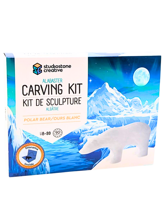 A box featuring an elegant, polished polar bear gainst a backdrop of a starkly beautiful glacier scene with the Northern Lights and a full moon. The banner featuring lettering reads "Alabaster Carving Kit: Polar Bear." It estimates 90 minutes to complete.